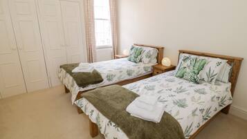 Un dormitorio con dos camas individuales, cada una con cabecero de madera y una mesita de noche.