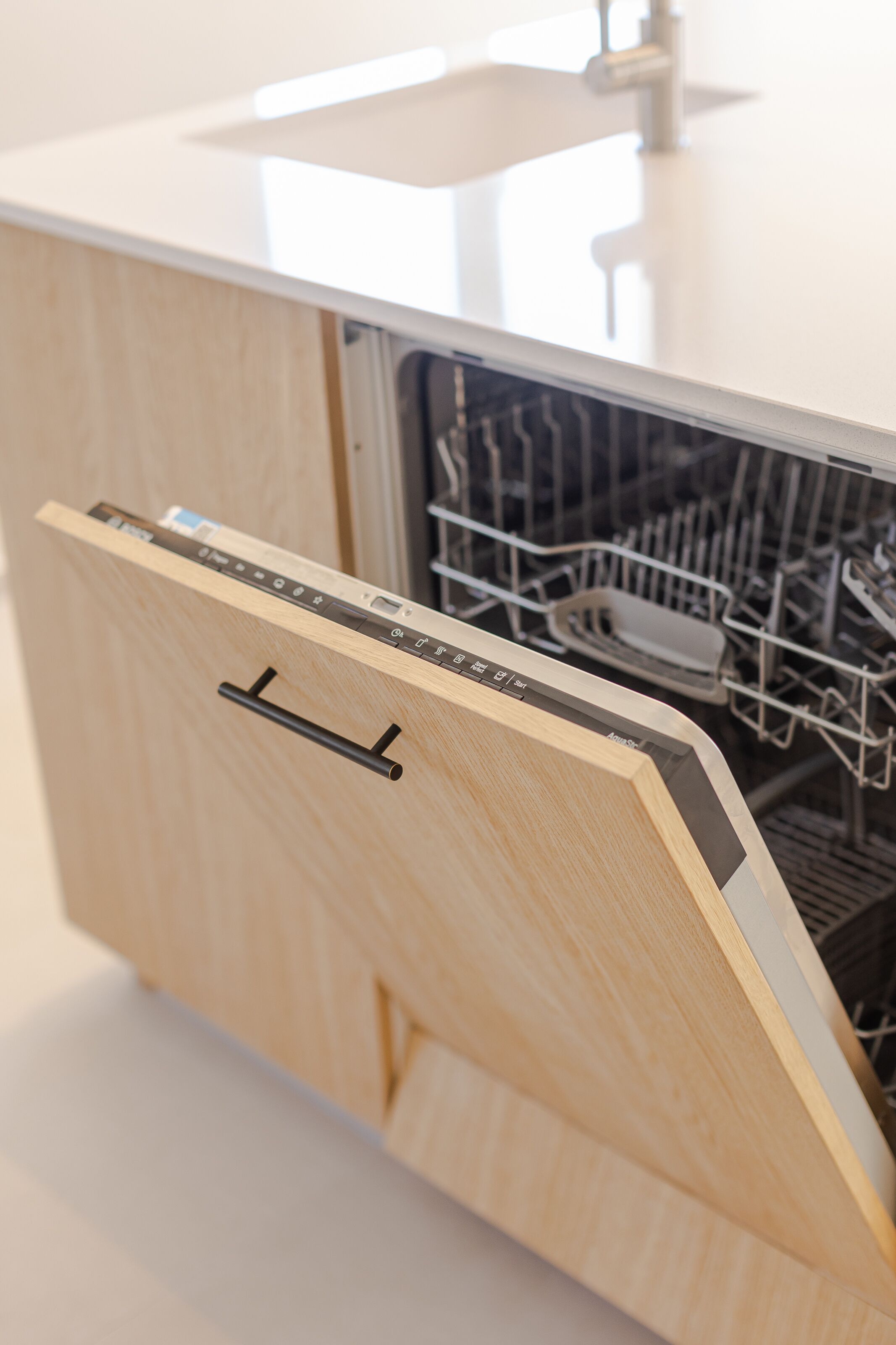 Eine moderne Küche mit Geschirrspüler und einem Holzkasten.