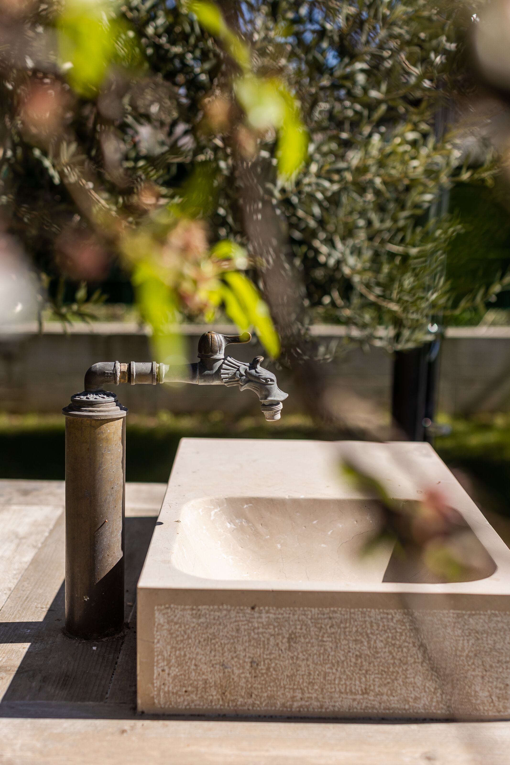A bathroom with a rectangular sink, a faucet, and a visible pipe.