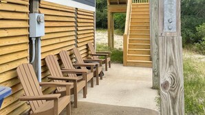 Un espace extérieur abrité, aménagé avec des chaises en bois et une terrasse en bois.