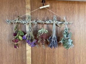 Una pared de madera con un resorte sujetando un hilo de flores y follaje secos.