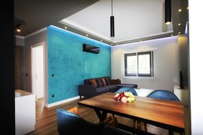 Deluxe-Apartment, Küche | Wohnbereich | 43-Zoll-Fernseher mit Satellitenempfang