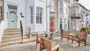 A terrace with wooden furniture and potted plants. - Host & Stay | Silver Beach (Whitby)