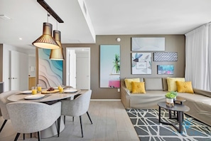 Una sala de estar moderna con un sofá, una mesa de comedor con sillas y una mesa baja.