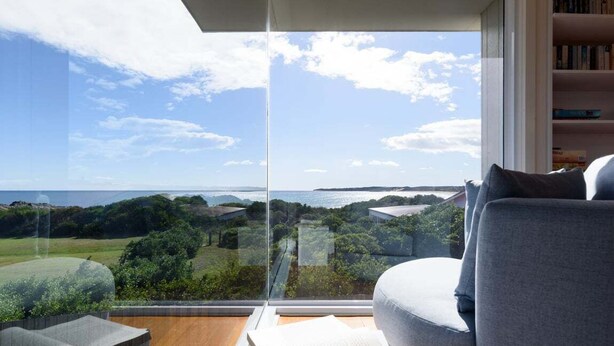 Un salon moderne doté d’une grande fenêtre donnant sur un paysage magnifique.