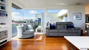 Un salon moderne avec un canapé, une table basse et une bibliothèque.