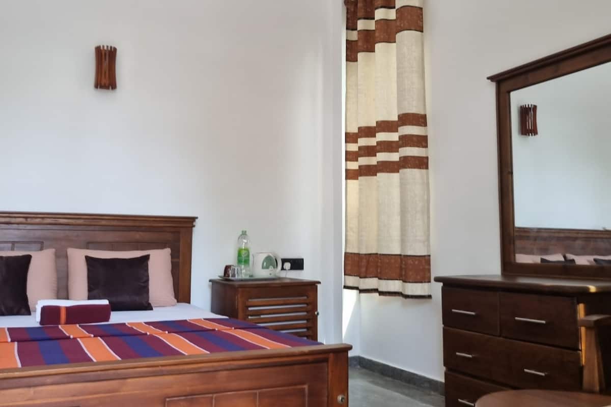 A bedroom with a wooden bed, a nightstand, a dresser, and a mirror.