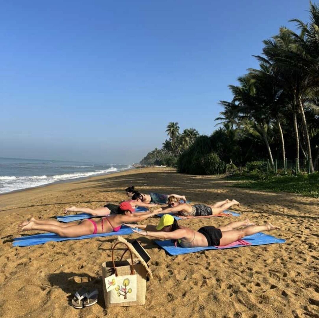 A beach scene with people sunbathing on towels.