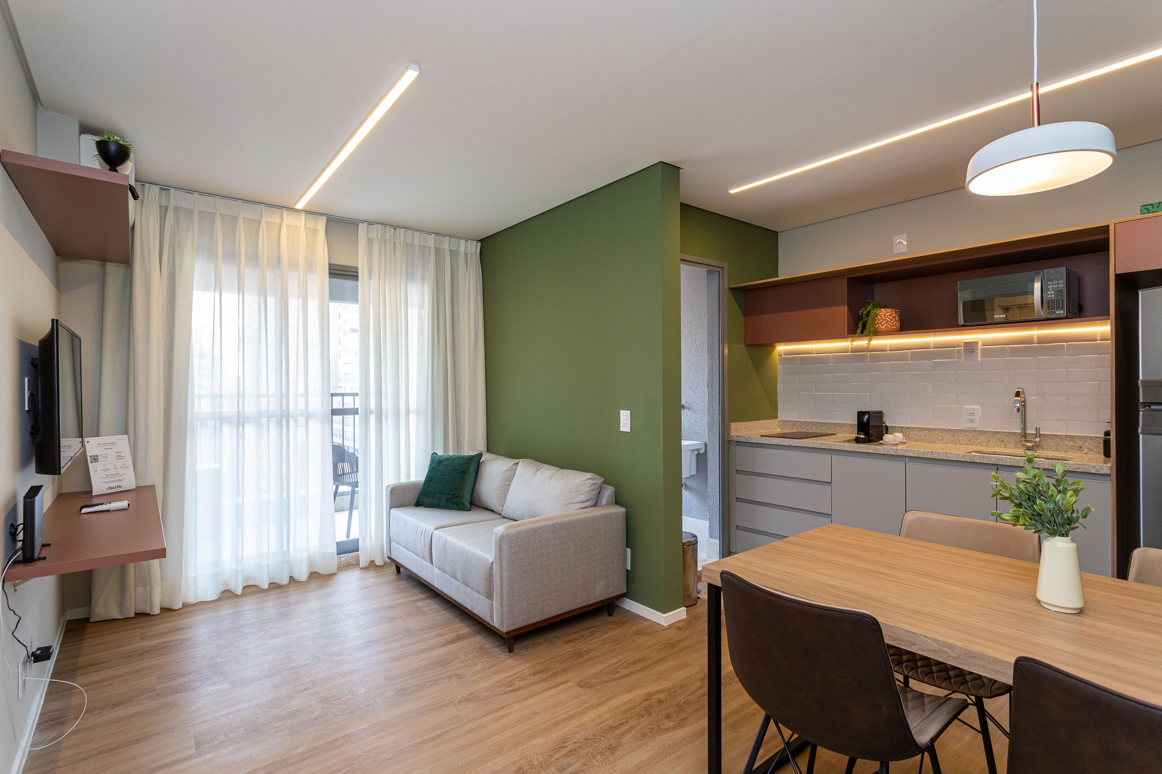 Een modern appartement met een bank, eettafel en keuken.