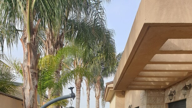 Un patio con mesa y sillas, una silla colgante y una fuente de agua.