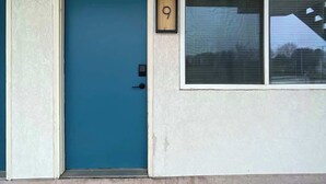 A building with a blue door, a window with blinds, and a small wooden plaque with a number. - Stand Rock Studios in Wisconsin Dells! (Wisconsin Dells)