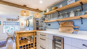 A kitchen with wooden shelves, a wooden island, and a 'Welcome' sign.