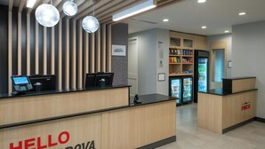 Un comptoir d’accueil avec une pancarte indiquant « BIENVENUE À CORDOVA », un ordinateur Lenovo, un réfrigérateur rempli de boissons et un comptoir « PINCH ».