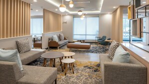 Un salon moderne comprenant un canapé, des fauteuils, une table basse et une bibliothèque.
