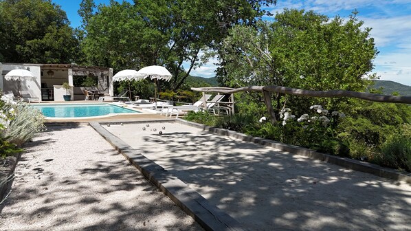Een buitenzwembad, parasols voor strand/zwembad
