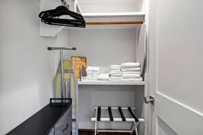 A walk-in closet with shelves for folded towels and a rack for hanging clothes. - South Lamar Wellness Haven / Sauna / Hot Tub / BBQ (Austin)