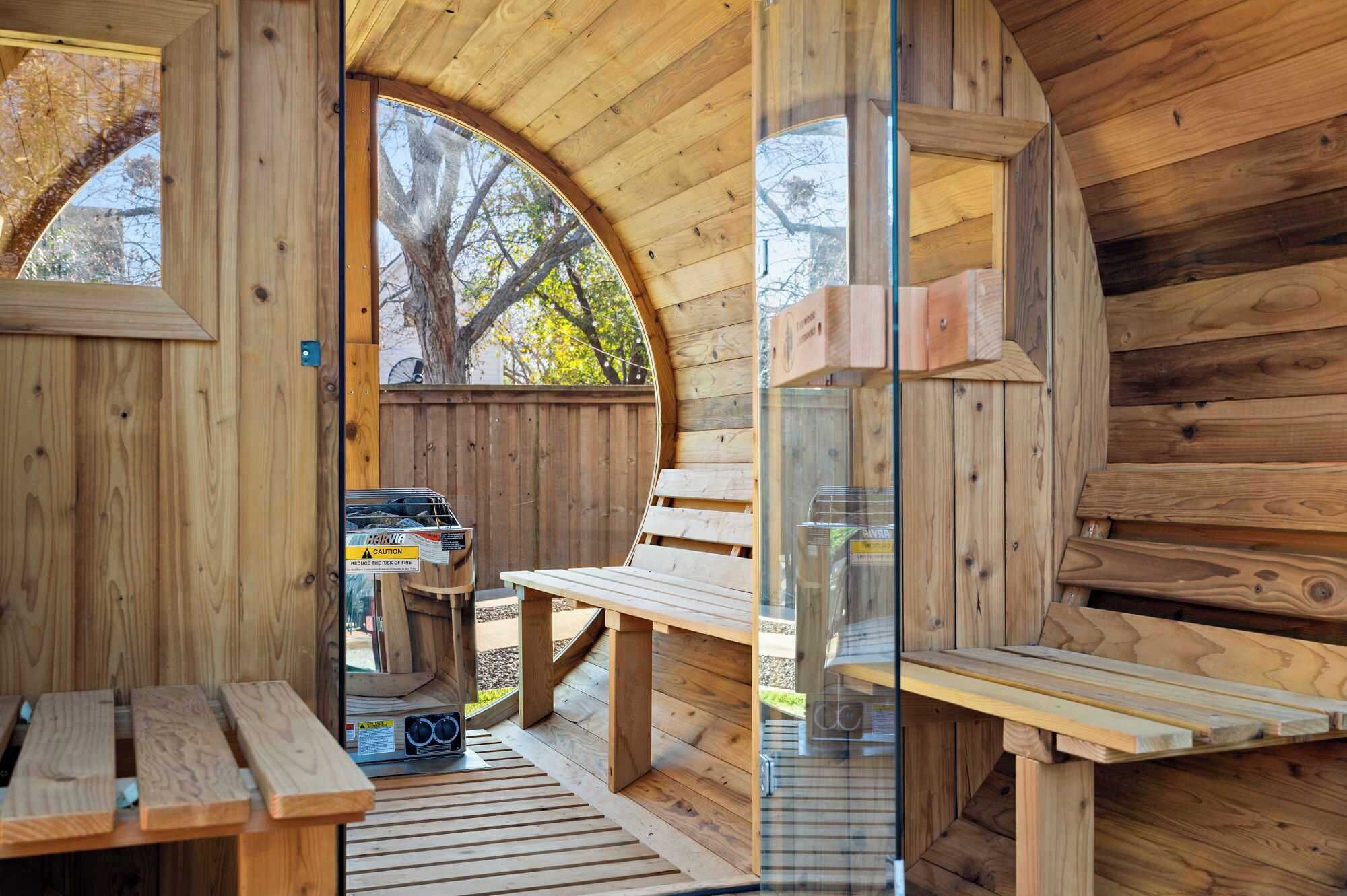 Una baita di legno con tetto curvo, un tavolo da picnic e una griglia per barbecue.