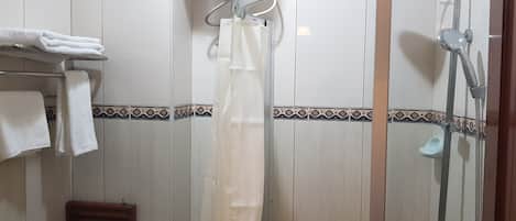 A bathroom with a shower, a towel rack with folded towels, and a toilet.