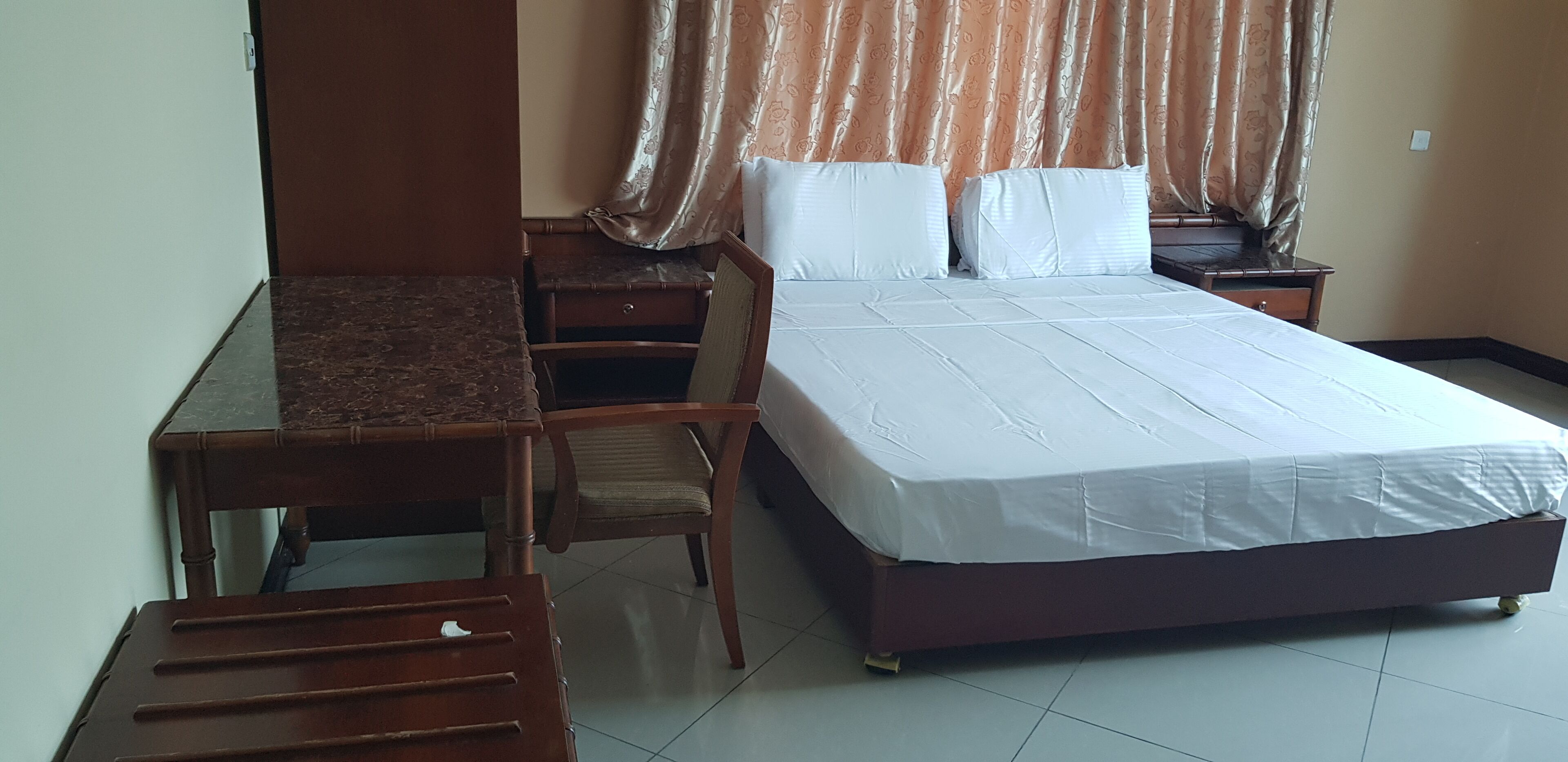 A bedroom with a bed, a desk, and a chair.
