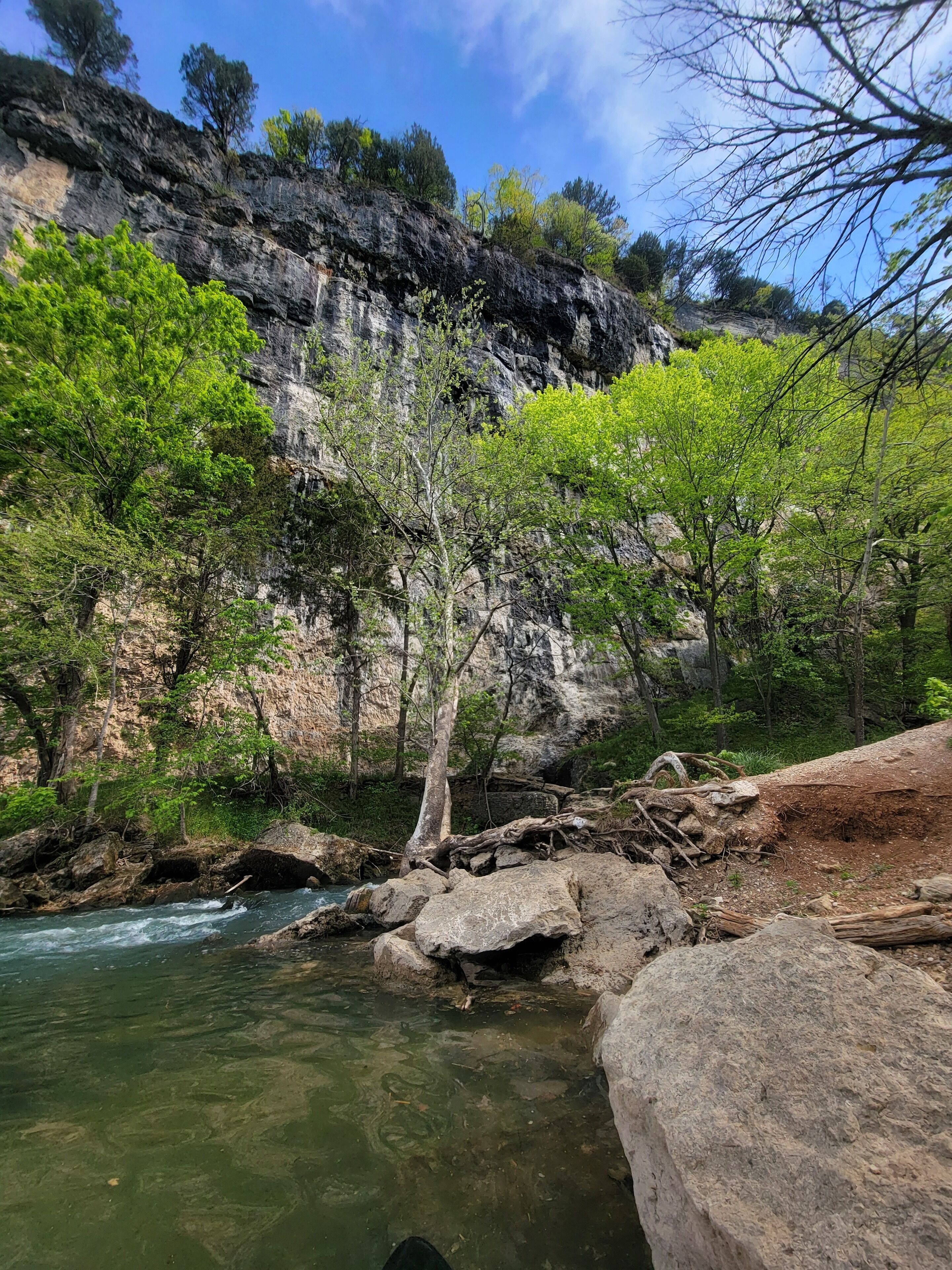 A river flowing through a rocky landscape with trees and cliffs.