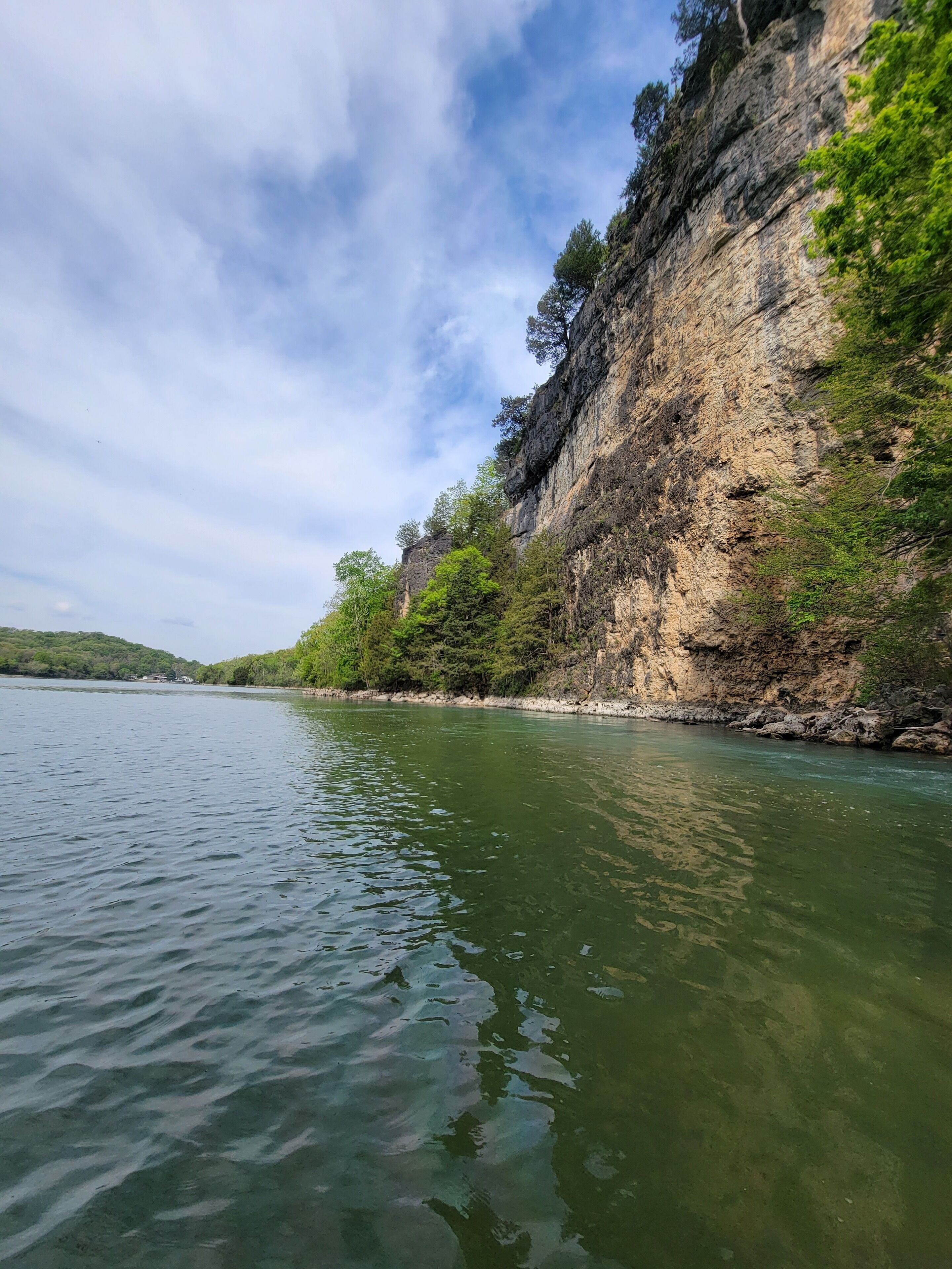 A river with a rocky cliff on one side.