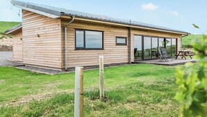Un bâtiment moderne en bois, doté de grandes fenêtres et d’un espace patio.