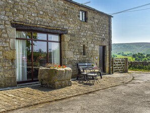A stone building with a large window, a bench, and a table outside. - 2 bedroom accommodation in Hebden, near Grassington (Hebden, near Grassington)