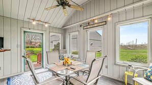 Ein Essbereich mit Tisch, Stühlen und Deckenventilator.