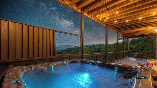 Ein Whirlpool mit Blick auf einen Sternenhimmel, eine Holzterrasse und eine Holzpergola.