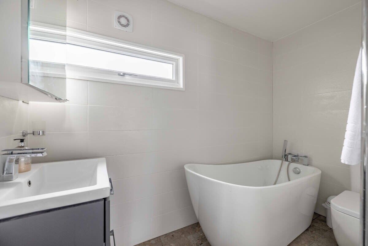 Une salle de bain moderne avec une baignoire sur pieds, un lavabo et des toilettes.