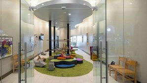 A modern interior with a circular seating area, glass walls, and a high ceiling.
