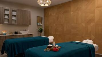 Experience serene relaxation in this tranquil spa room, featuring two massage tables with plush pillows and basins, a geometric-patterned wall, and a soothing ambiance.