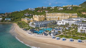 A resort with a beachfront, multiple buildings, and a pool area.