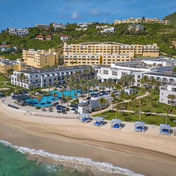 A resort with a beachfront, multiple buildings, and a pool area.