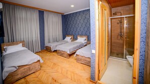 A hotel room with three wooden beds, a shower area, and a large window with curtains. - samta (Tsqaltubo)