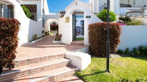 A white building with a paved pathway leading to a door marked with the number 6. - Las Golondrinas by Interhome (Nerja)