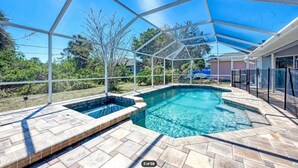 A covered swimming pool with a clear blue water feature, surrounded by a white metal frame and a blue canopy. - Salt Water Pool & Spa Escape (North Port)