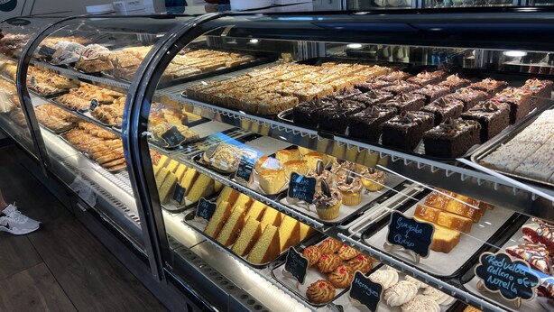 Una vitrina de pastelería con diferentes productos horneados.