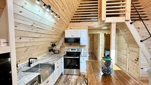 Une cuisine moderne avec des murs en bois, un escalier en bois et un coin repas.