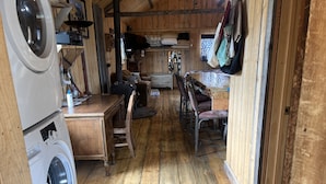 Een wasserette met een wasmachine, een houten tafel en stoelen.