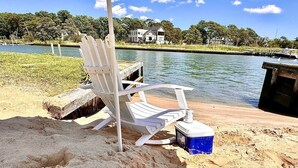A beach chair by a dock with a cooler on the sand. - Waterfront | Minutes to US Open| Private Water Access (Hampton Bays)