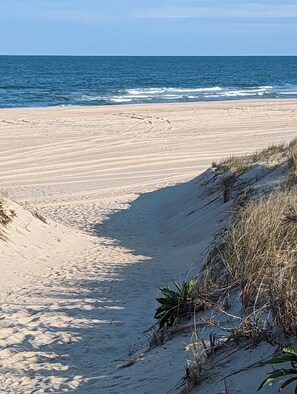 A sandy beach with gentle waves and a clear sky.
