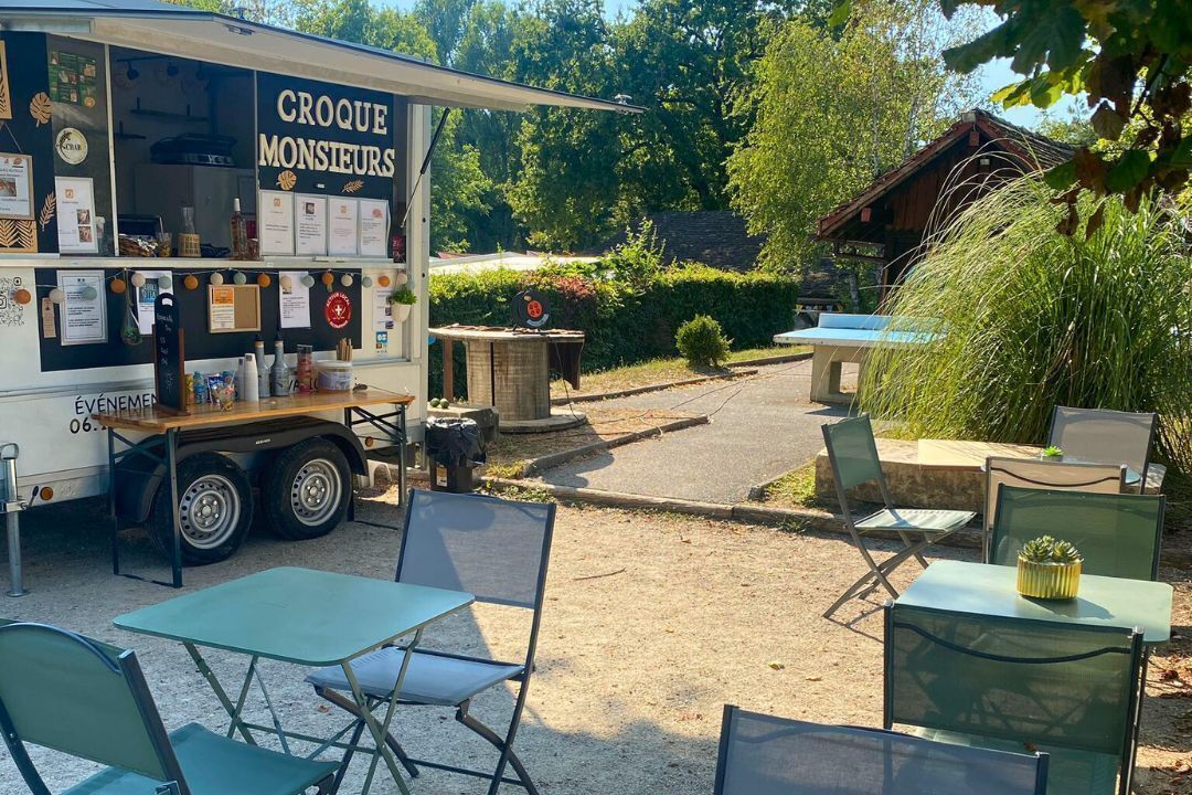 A food truck named 'Croque Monseurs' with outdoor seating and a garden area.