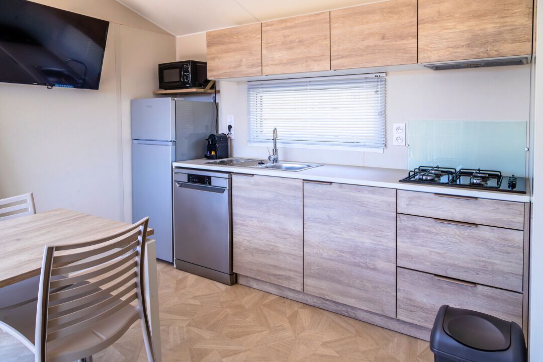 Una cocina compacta con refrigerador, microondas, pileta y estufa.