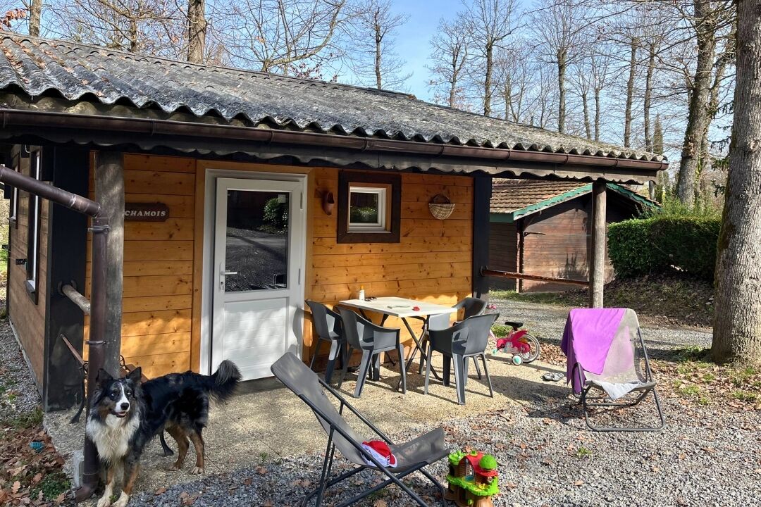 A wooden cabin with a door, a table, and two chairs.