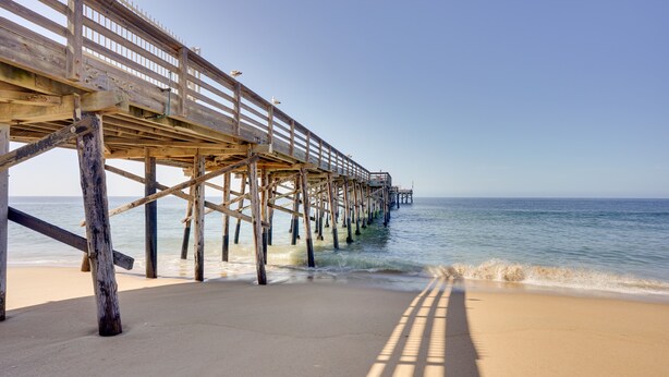 A wooden pier extending into calm waters with a clear sky. - Newport Beach Vacation Rental Near Beach & Pier (Newport Beach)