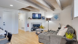A living room with a fireplace, sofa, and television. - Newport Beach Vacation Rental Near Beach & Pier (Newport Beach)