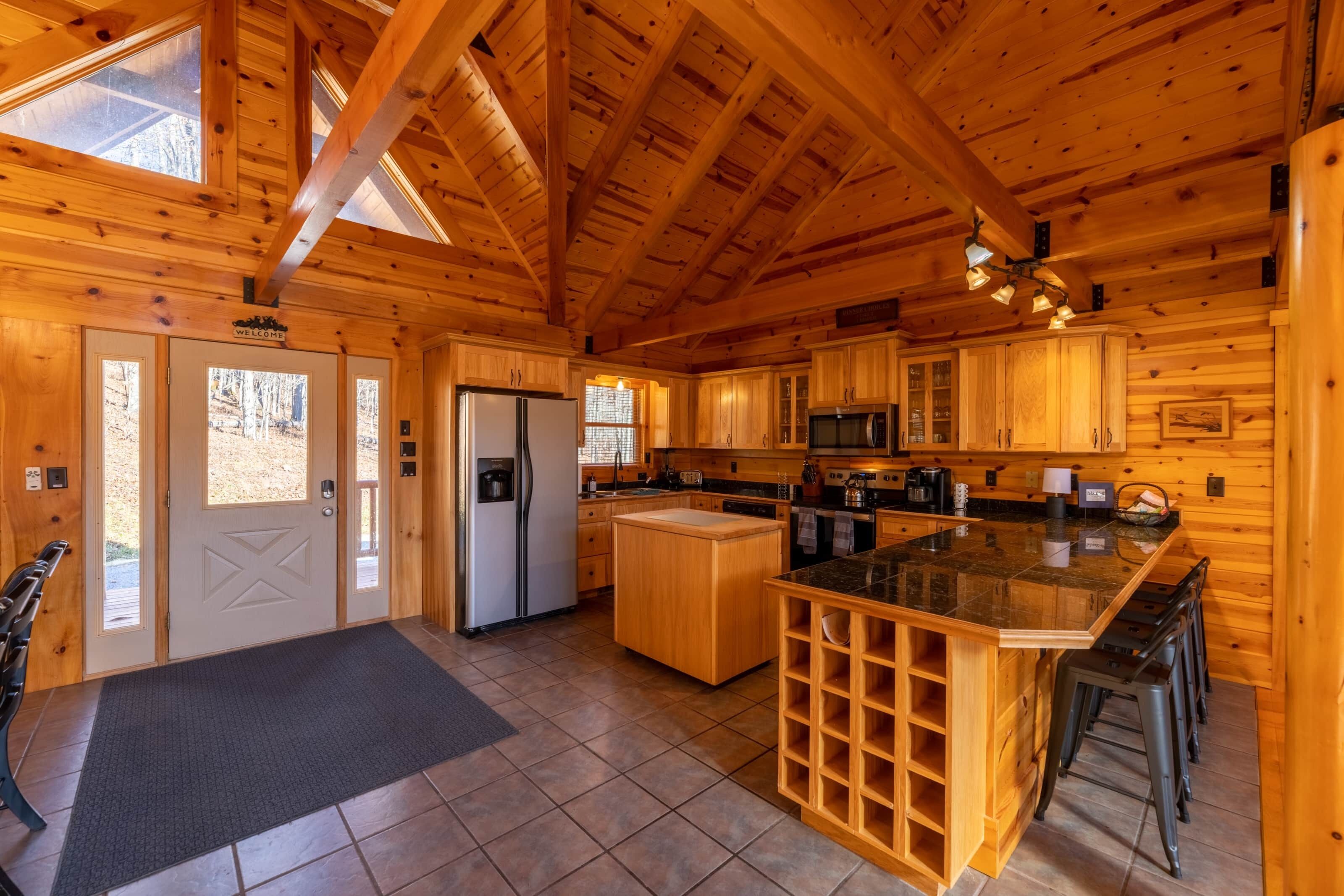 Une cuisine de style rustique, avec des meubles en bois, un îlot central et un réfrigérateur.
