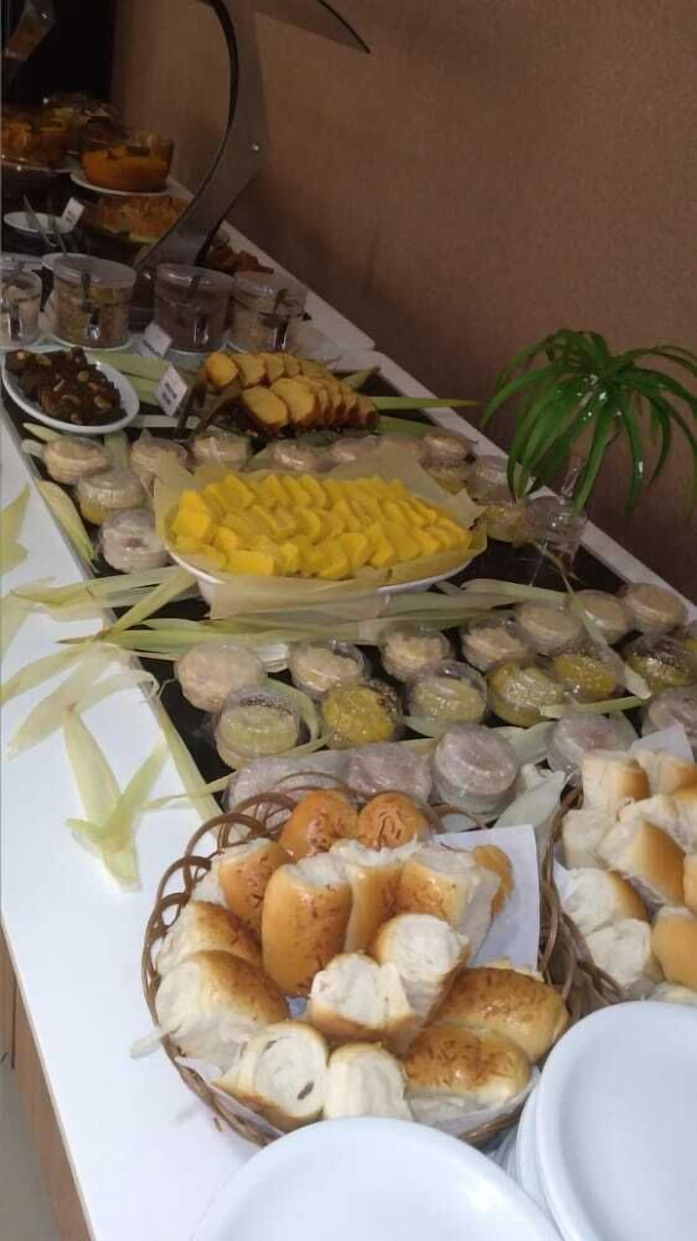 A buffet table with various food items including bread, fruits, and condiments.