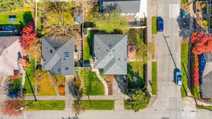 An aerial view of a residential area with houses, a street, and a parking lot. - Lilac in Law (Seattle)
